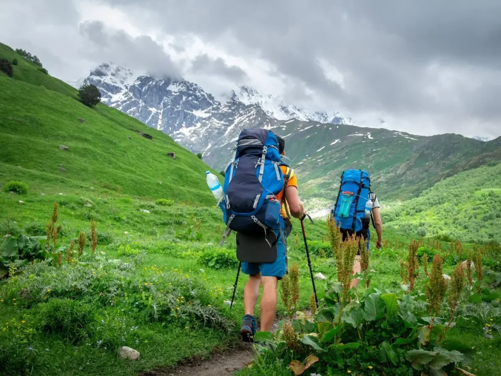 Places to Visit in Himachal Pradesh, Group of trekkers hiking on a scenic mountain trail near Jalori Pass, heading towards Serolsar Lake, Himachal Pradesh.